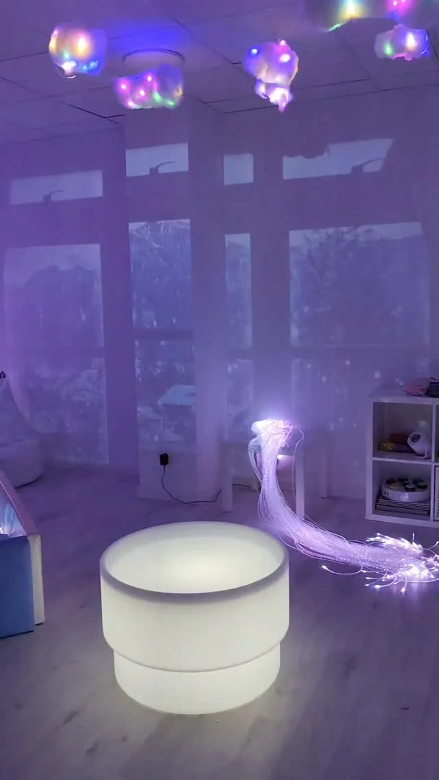 Mesa de luz redonda y haz de fibras ópticas iluminadas en la sala sensorial